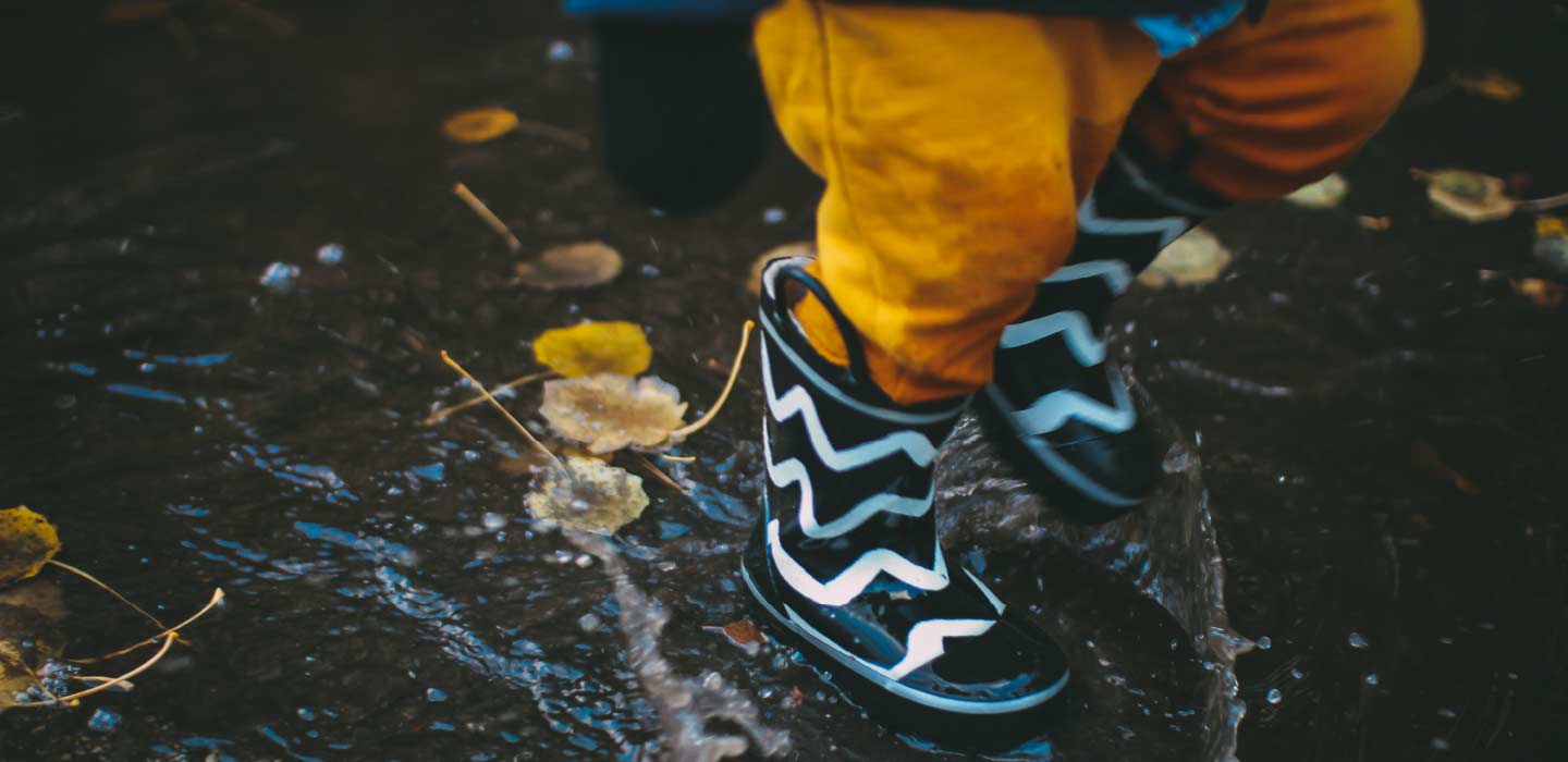 kid playing in puddles at our holiday camp