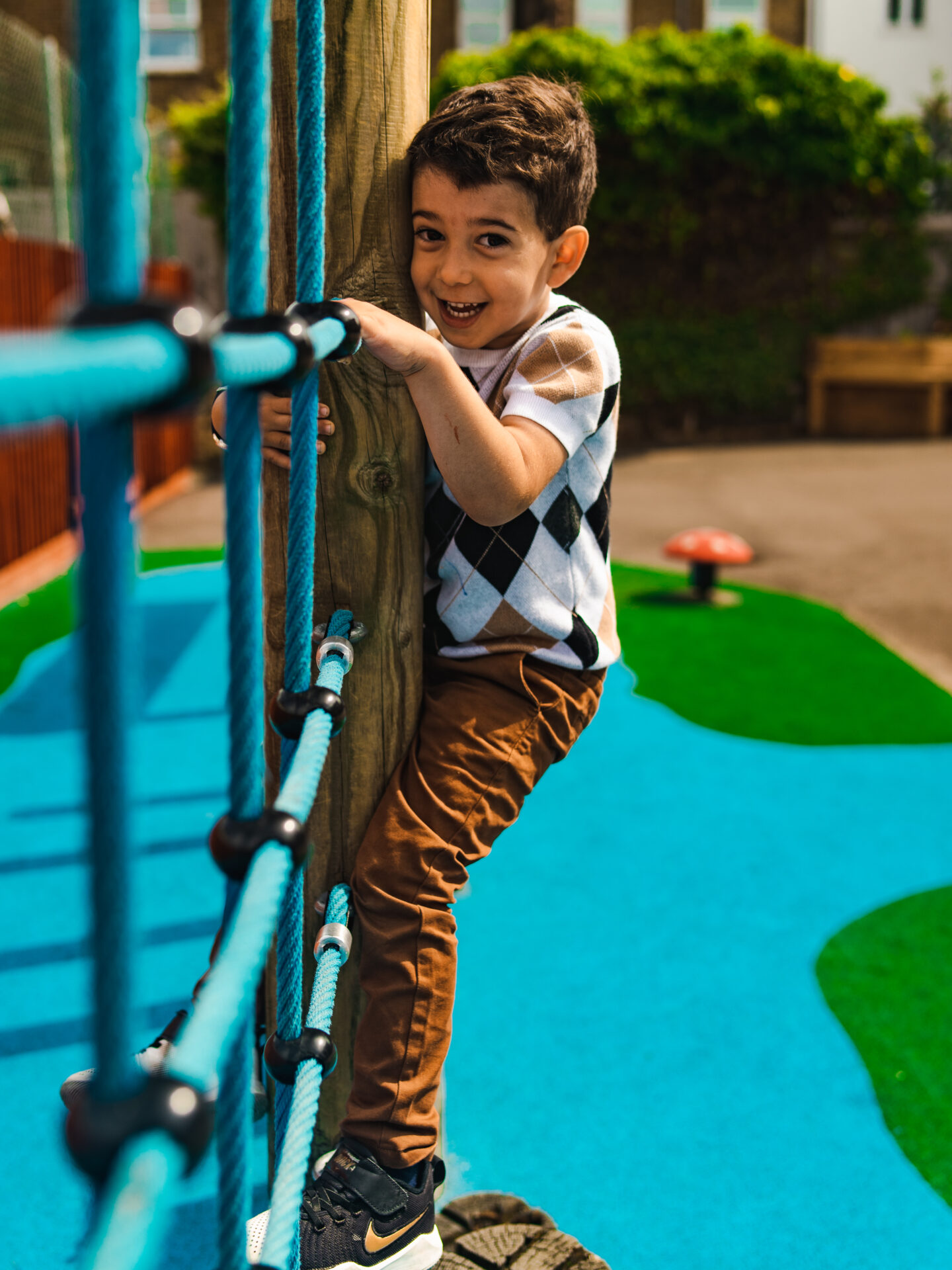 boy on climbing frame at holiday camp