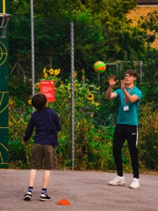 Child playing basketball with coach